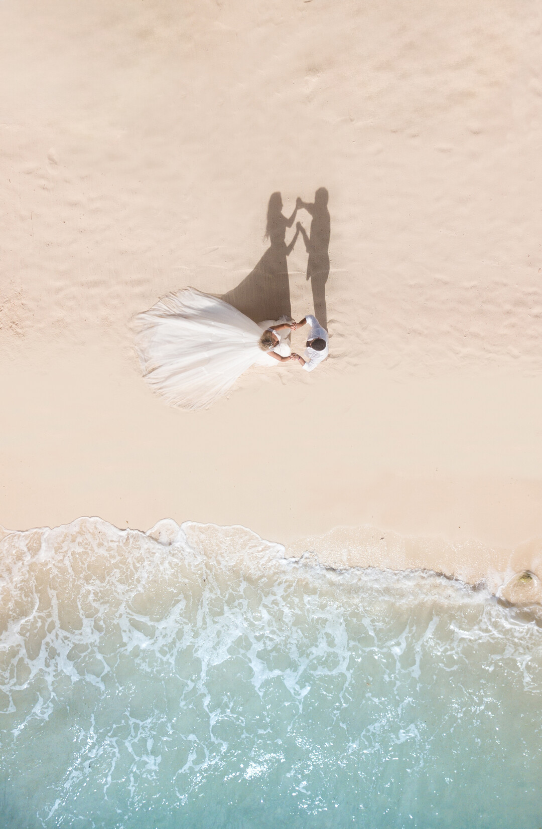 Wedding couple on a beach, drone top-down shoot; Shutterstock ID 1689589294; purchase_order: -; job: -; client: -; other: -